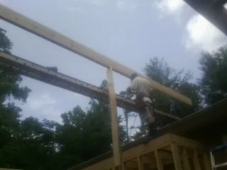 Carpenter setting a ridge beam over a new addition frame — Ice Dam Removal by Roofing Brothers in Ridgely