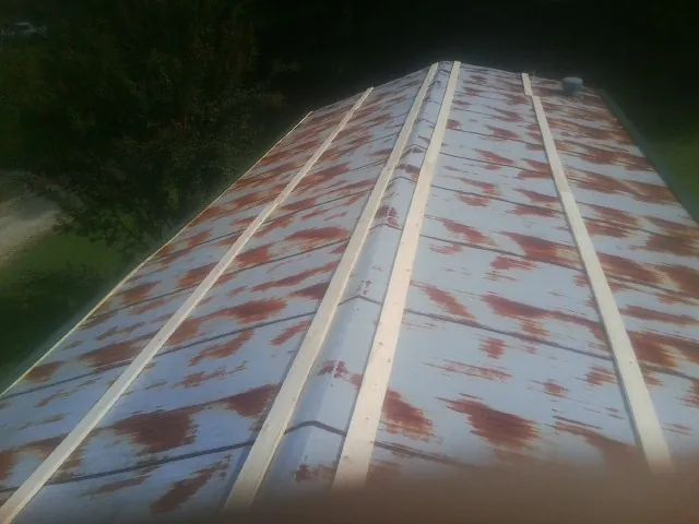Rusted metal roof panels with new wood purlins before replacement — Storm Damage Roof Repair in Ridgely by Roofing Brothers