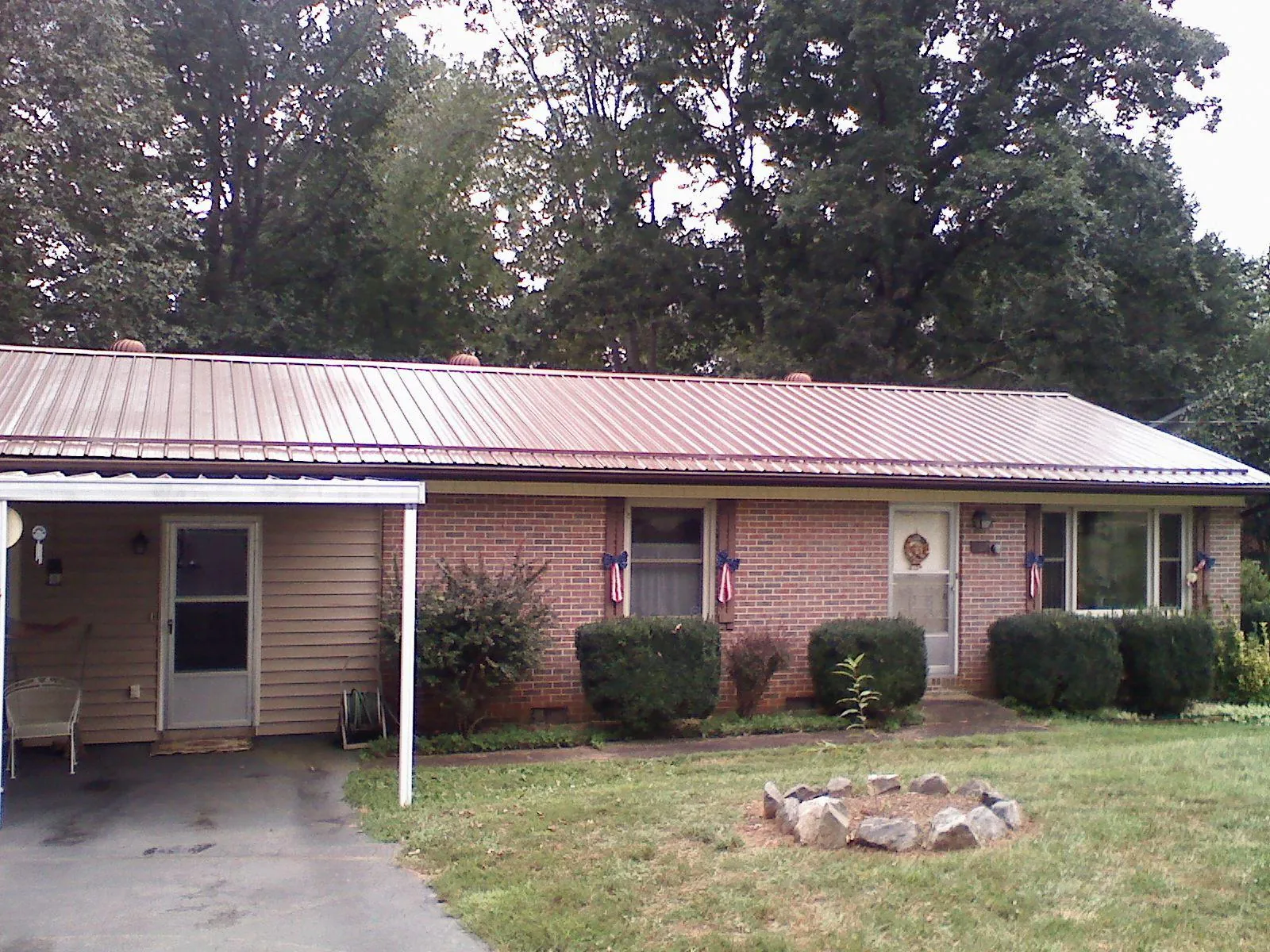 Bronze metal roof and carport on a brick ranch home — Roof Repair work by our crew in Ridgely